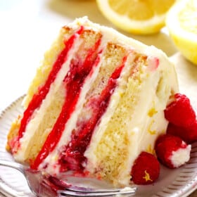 up close of a bite of of Raspberry Lemon Cake showing the raspberry filling and tender cake