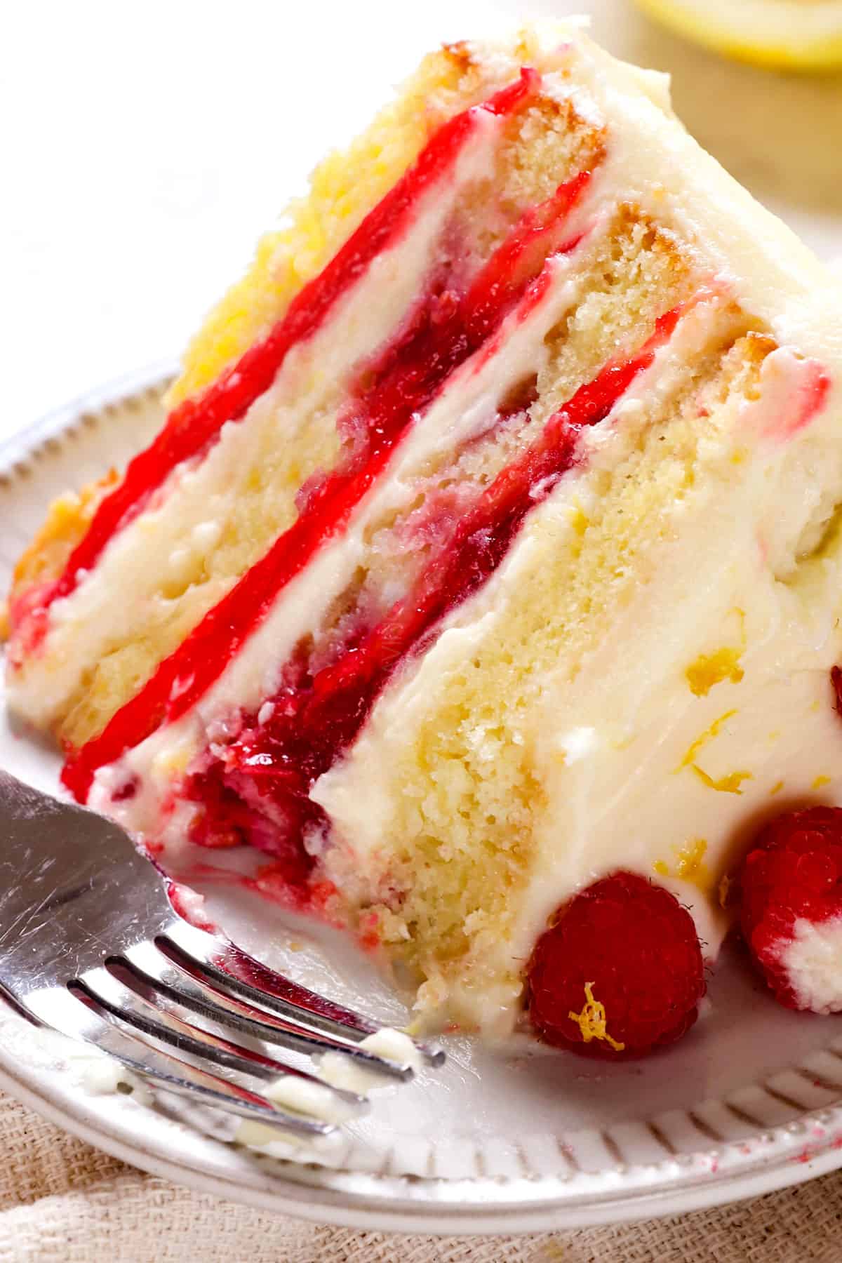 up close of a bite of of Raspberry Lemon Cake showing the raspberry filling and tender cake