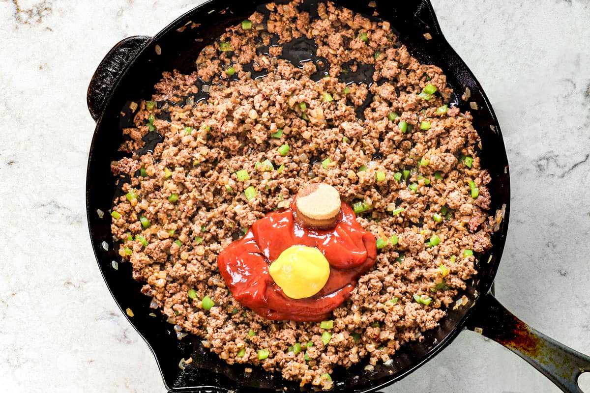 showing how to make sloppy joes by adding ketchup, mustard, Worcestershire, vinegar and brown sugar to the ground beef in the skillet