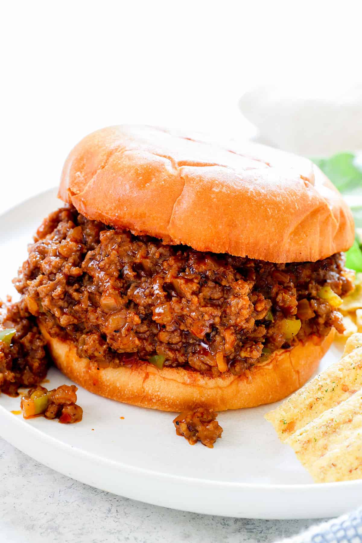 showing how to make sloppy joe recipe by adding the filling to toasted buns