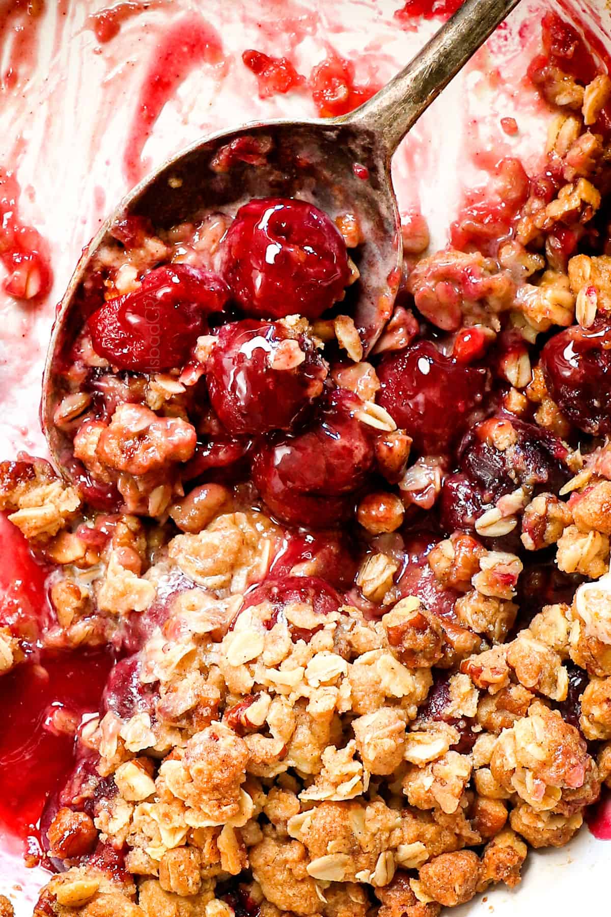 up close of scooping up cherry crisp recipe showing the tender cherries