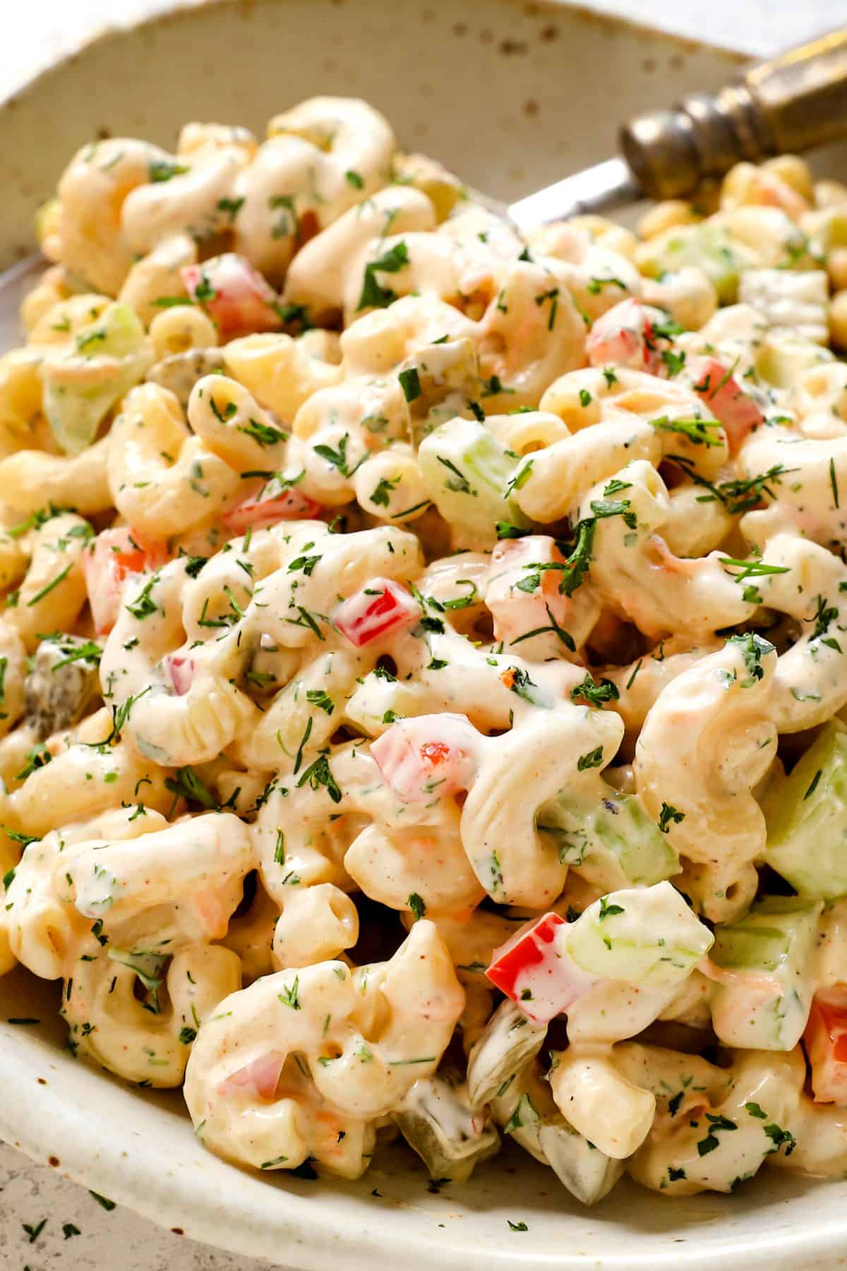 serving macaroni salad recipe on a plate garnished with dill 