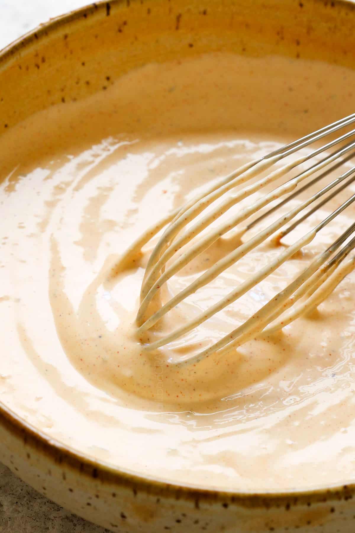whisking remoulade sauce ingredients together showing how creamy it is
