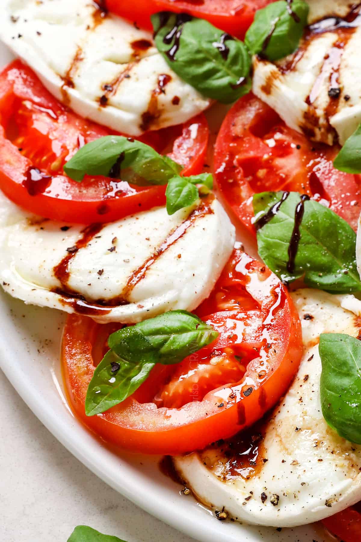 up close of Caprese Salad with tomatoes and mozzarella slices showing how thick the slices are