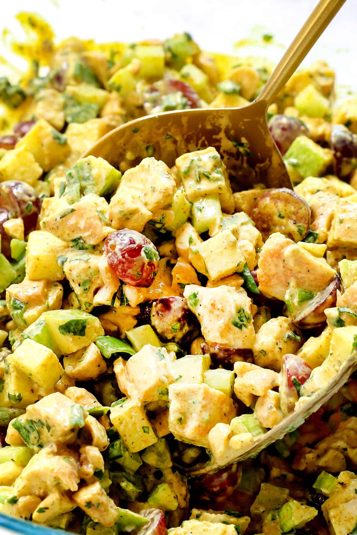 up close of scooping up curry chicken salad recipe to serve