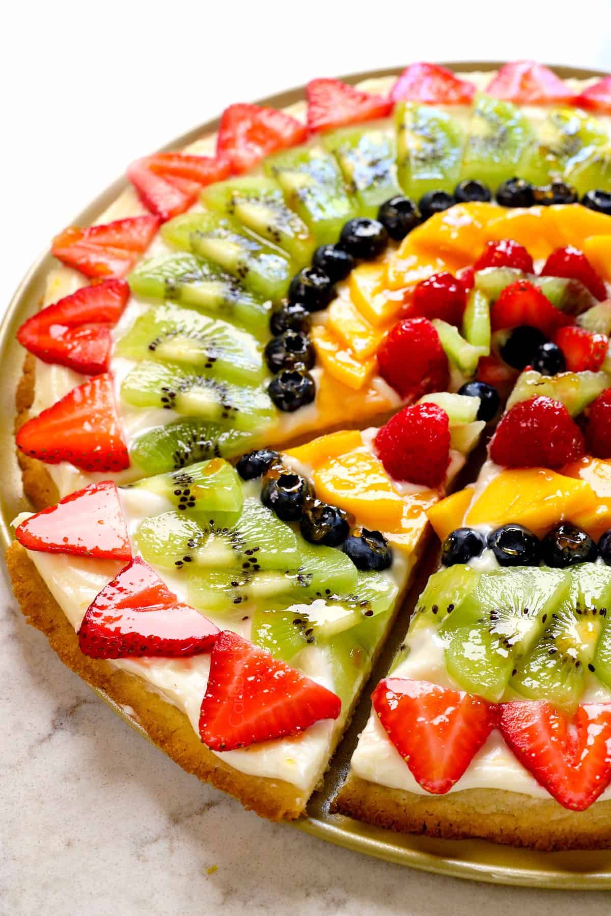 showing how to serve fruit pizza by cutting into slices