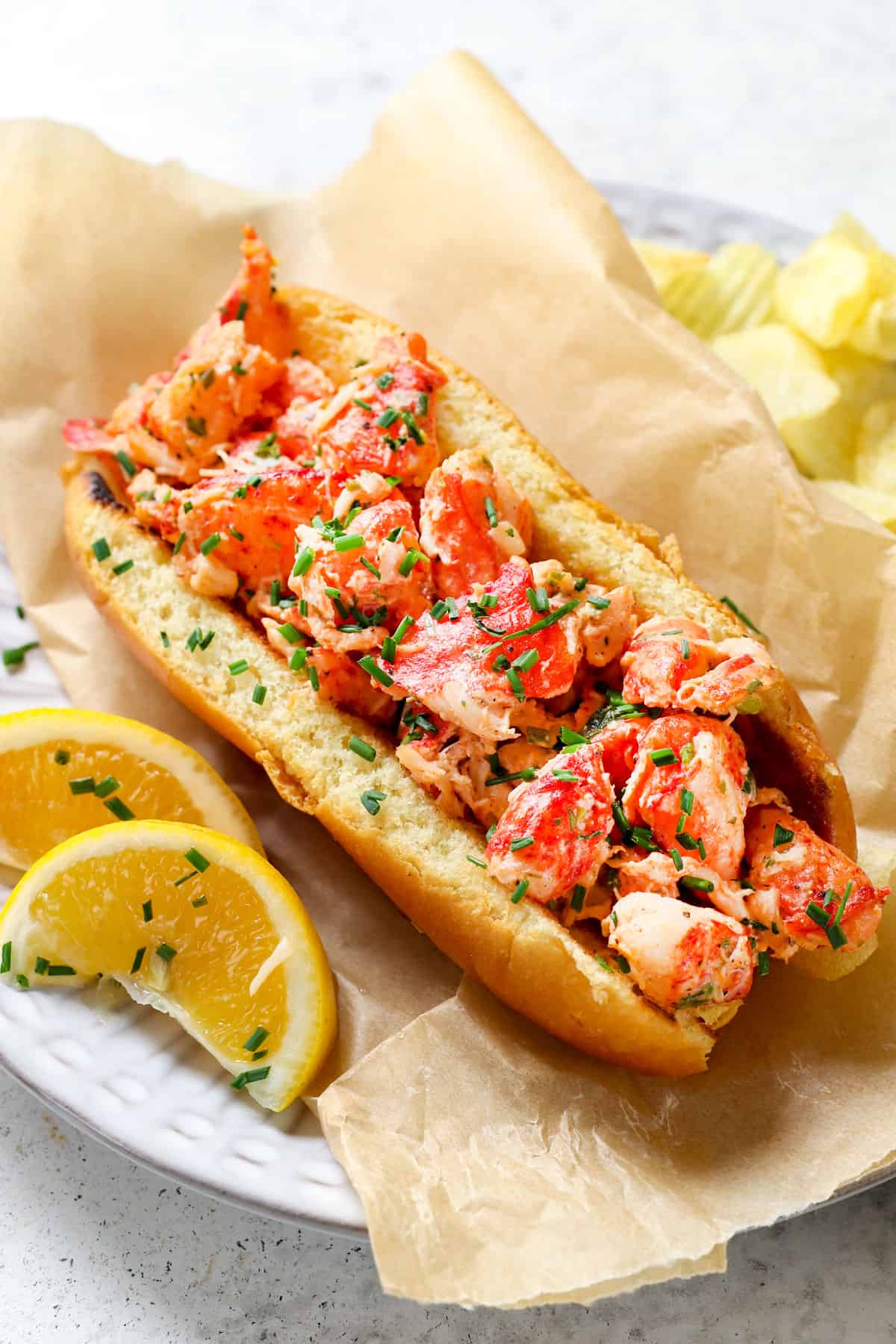 showing how to serve Main lobster rolls on a plate with potato chips