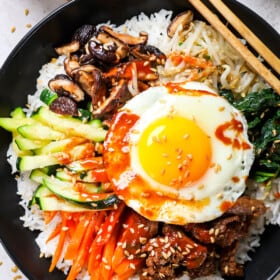 top view of bibimbap showing how to assemble the bowls with rice, vegetables and beef