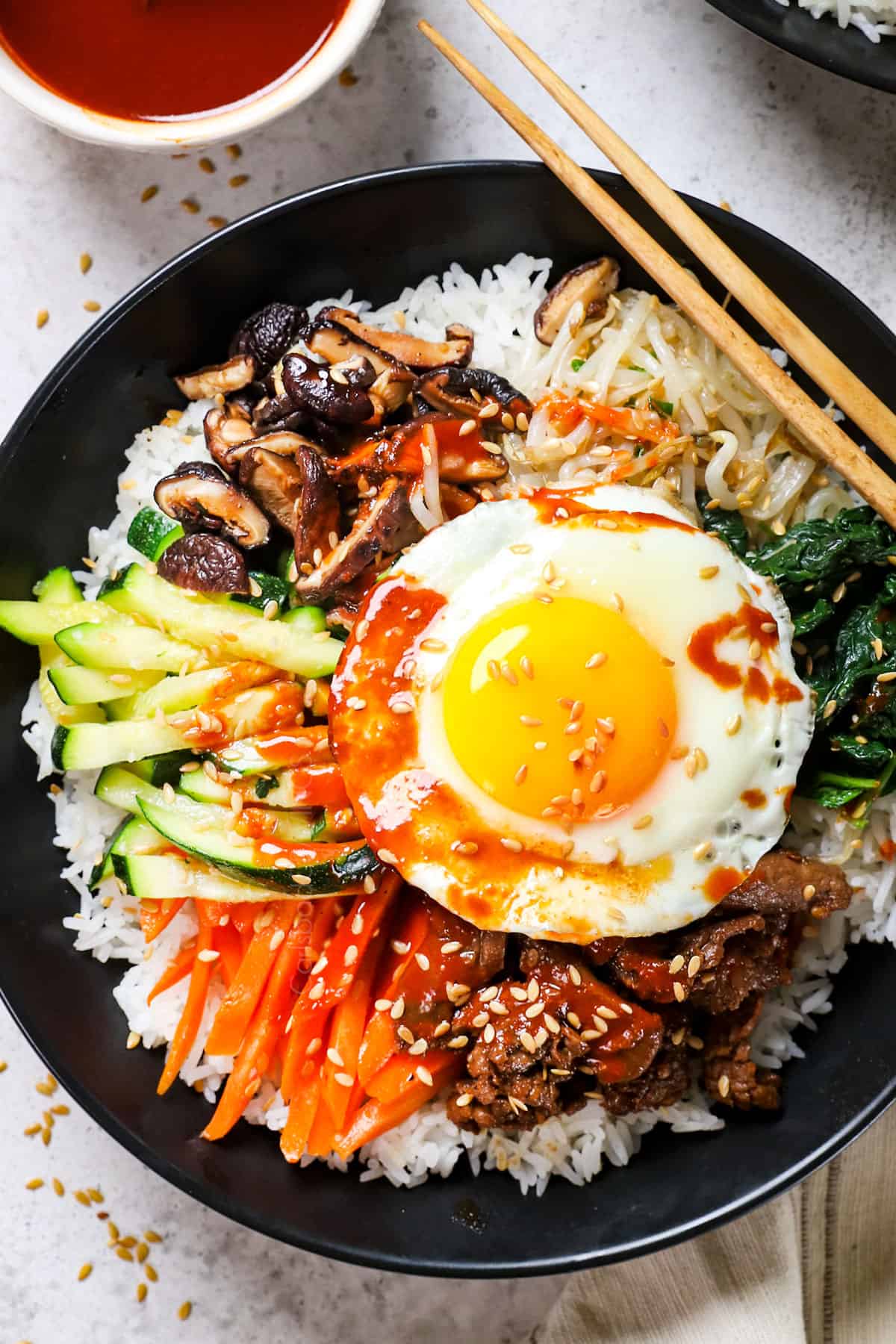 top view of bibimbap showing how to assemble the bowls with rice, vegetables and beef