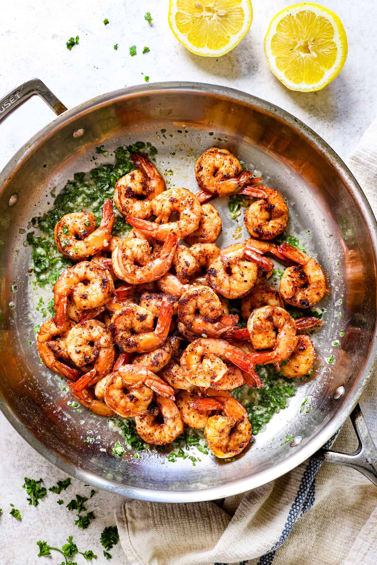 showing how to make Cajun Shrimp recipe by add cooked shrimp to butter in a pan
