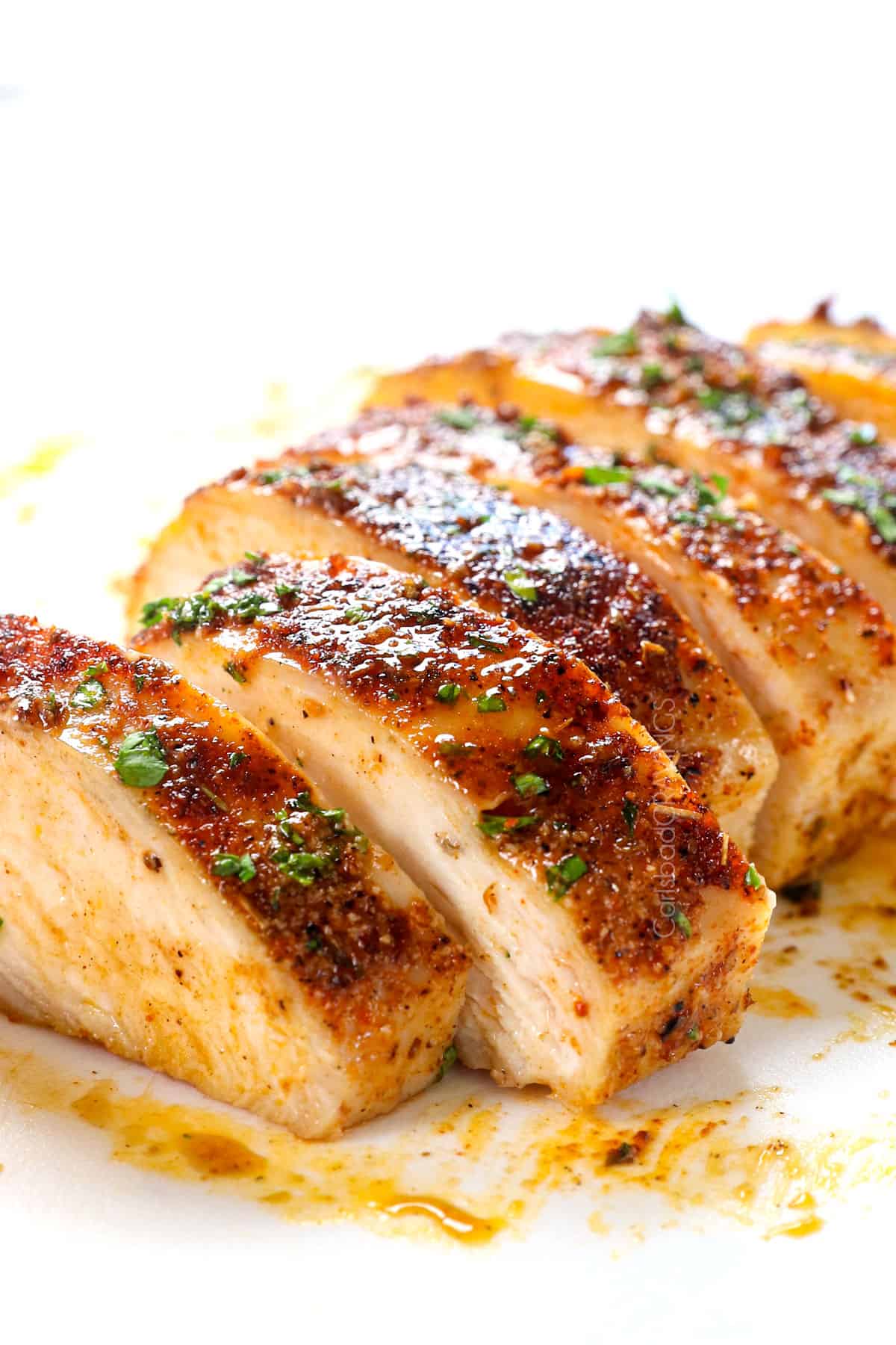 oven baked chicken breast sliced on a cutting board showing how juicy it is