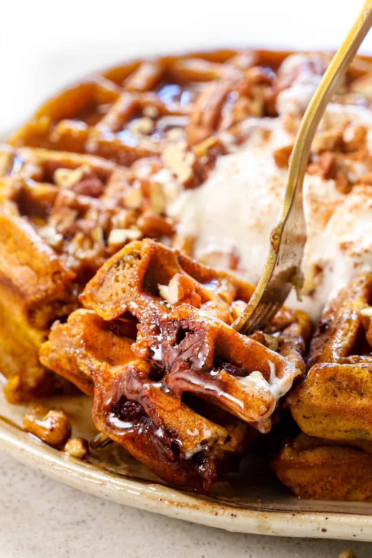 up close of taking a bite of pumpkin spice waffles showing the chocolate chips
