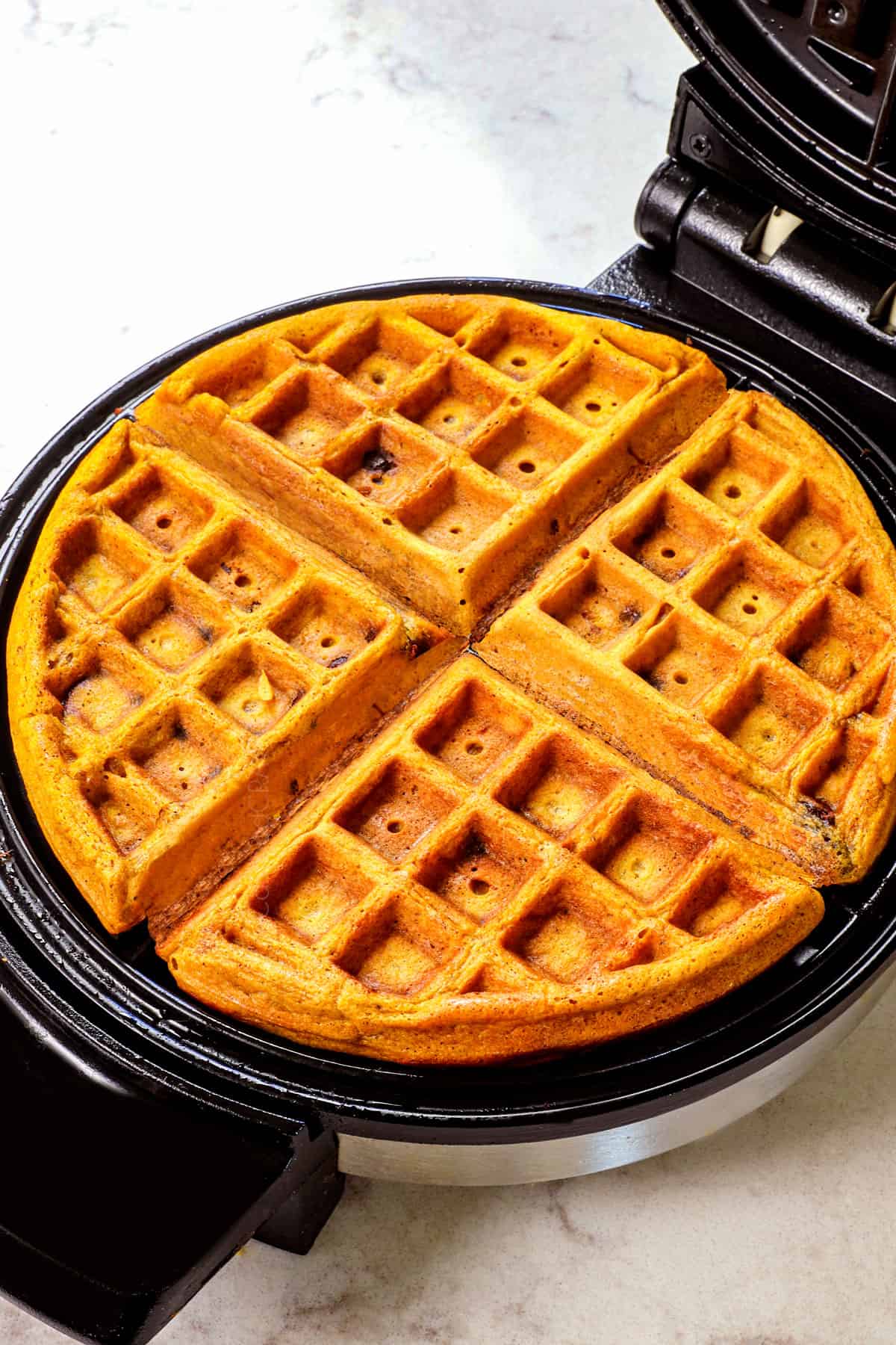 showing how to make pumpkin waffles by cooking in a waffle iron until crispy on the outside and soft on the inside