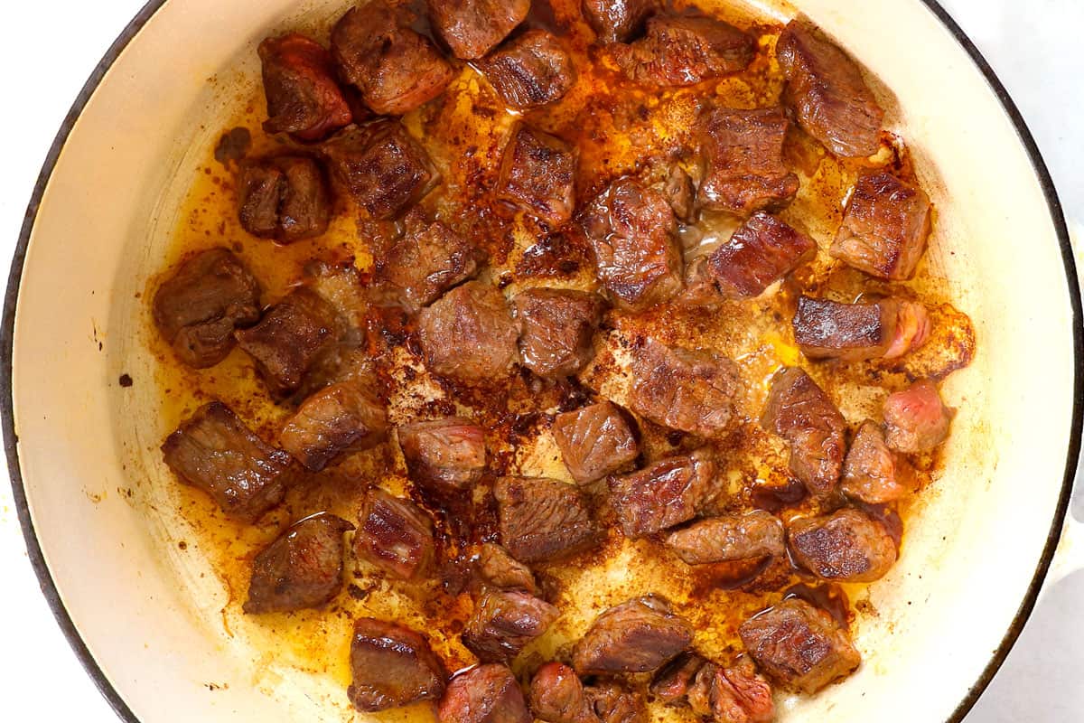 showing how to make chili con carne (beef chili) by searing cubes of chuck roast in a Dutch oven