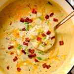 top view of best best potato soup recipe with a ladle spooning the soup