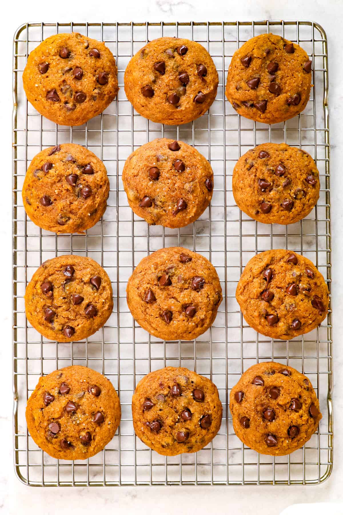 showing how to make pumpkin chocolate chip cookies by cooling pumpkin cookies on a wire rack