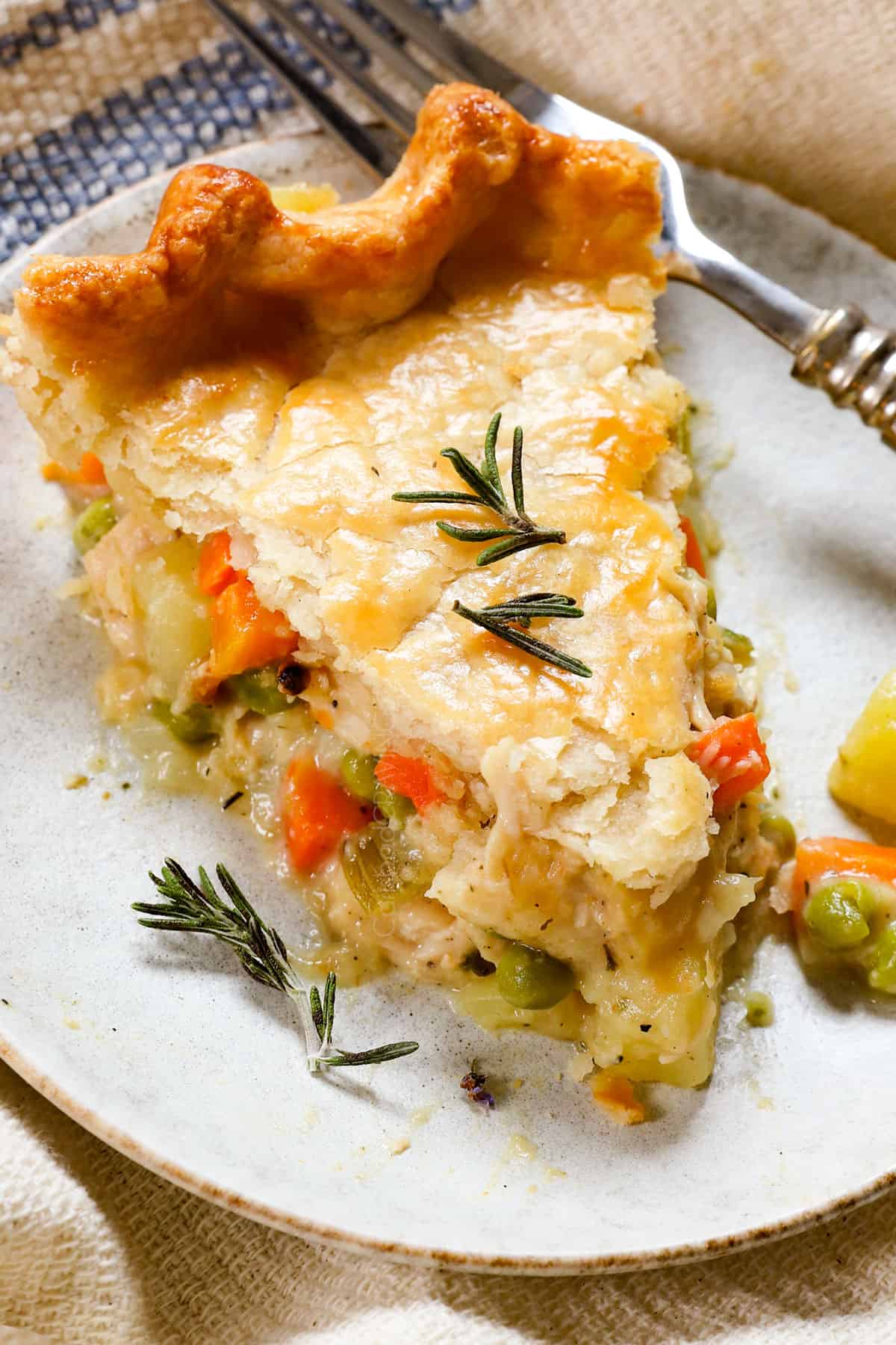 a slice of turkey pot pie on a plate showing the filing on the sides