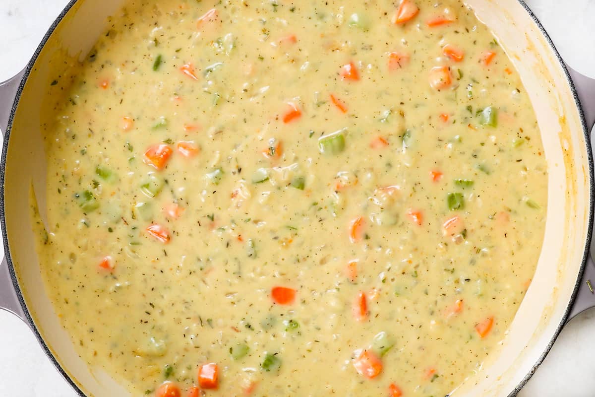 showing how to make turkey pot pie recipe by simmering the sauce until thickened