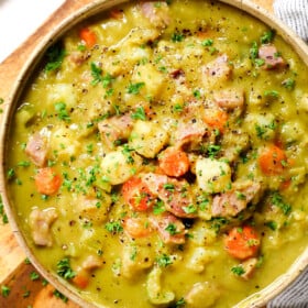 showing how to serve split pea soup with ham by adding to a bowl and garnishing with parsley