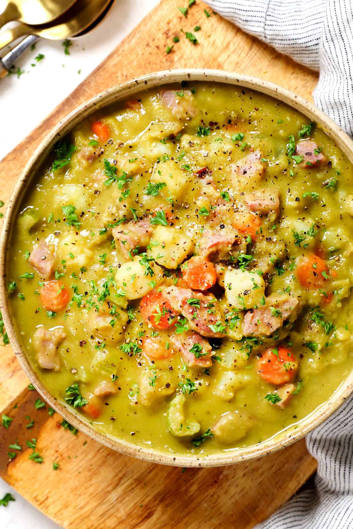 showing how to serve split pea soup with ham by adding to a bowl and garnishing with parsley