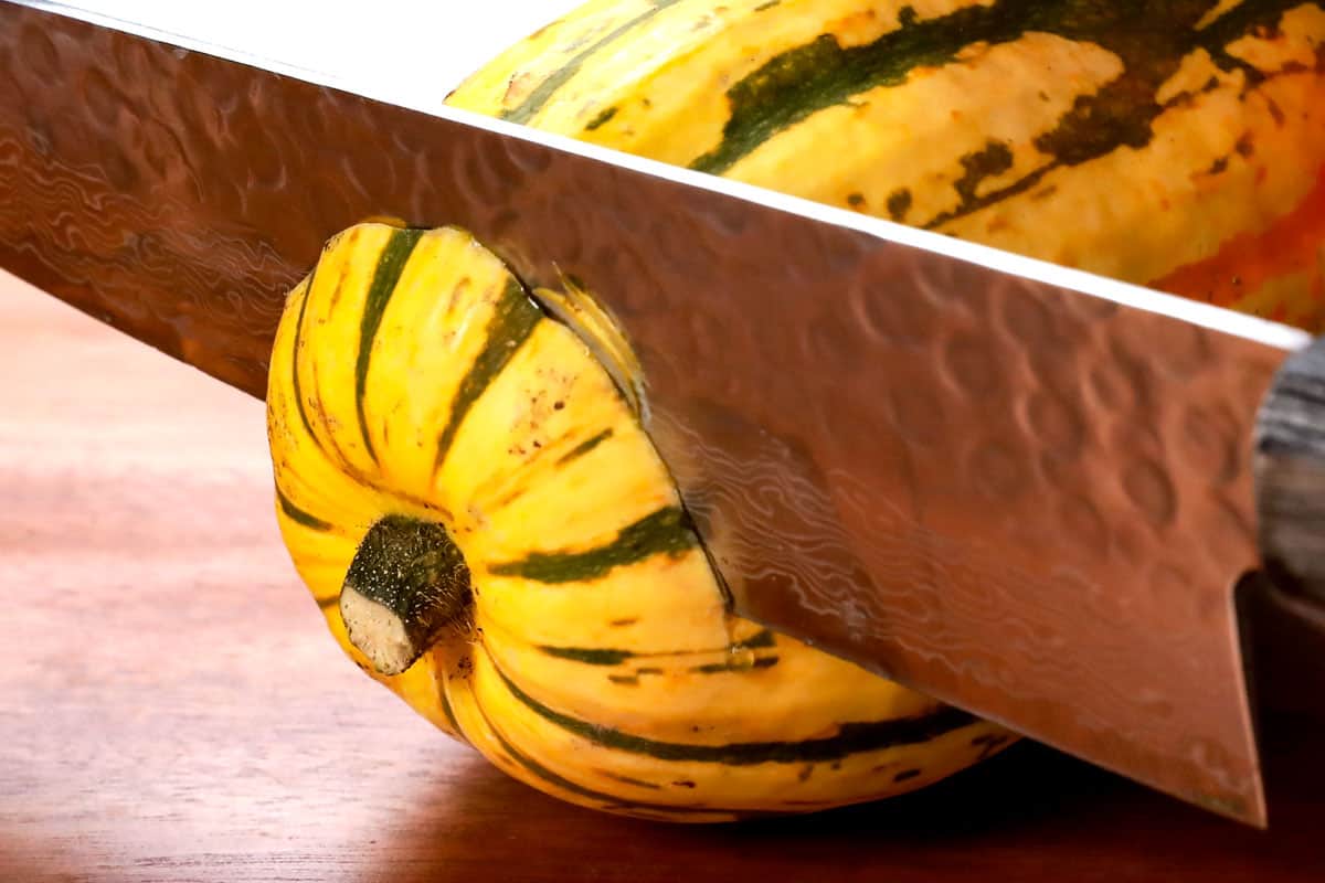 showing how to make delicata squash recipe by trimming both of the ends off