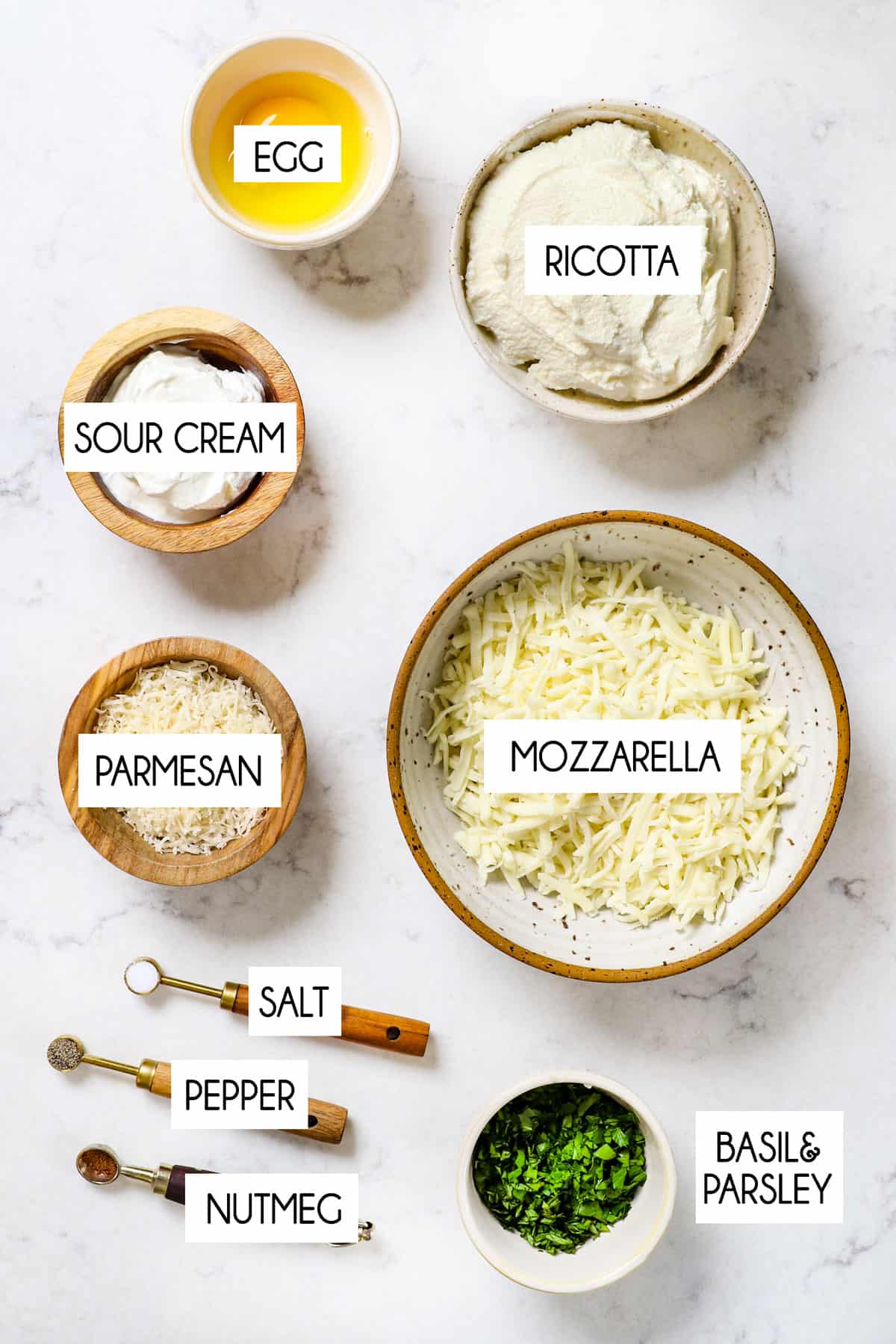 Showing Lasagna Roll Up ingredients:  ricotta, sour cream, mozzarella, Parmesan, basil, egg, salt, pepper, nutmeg