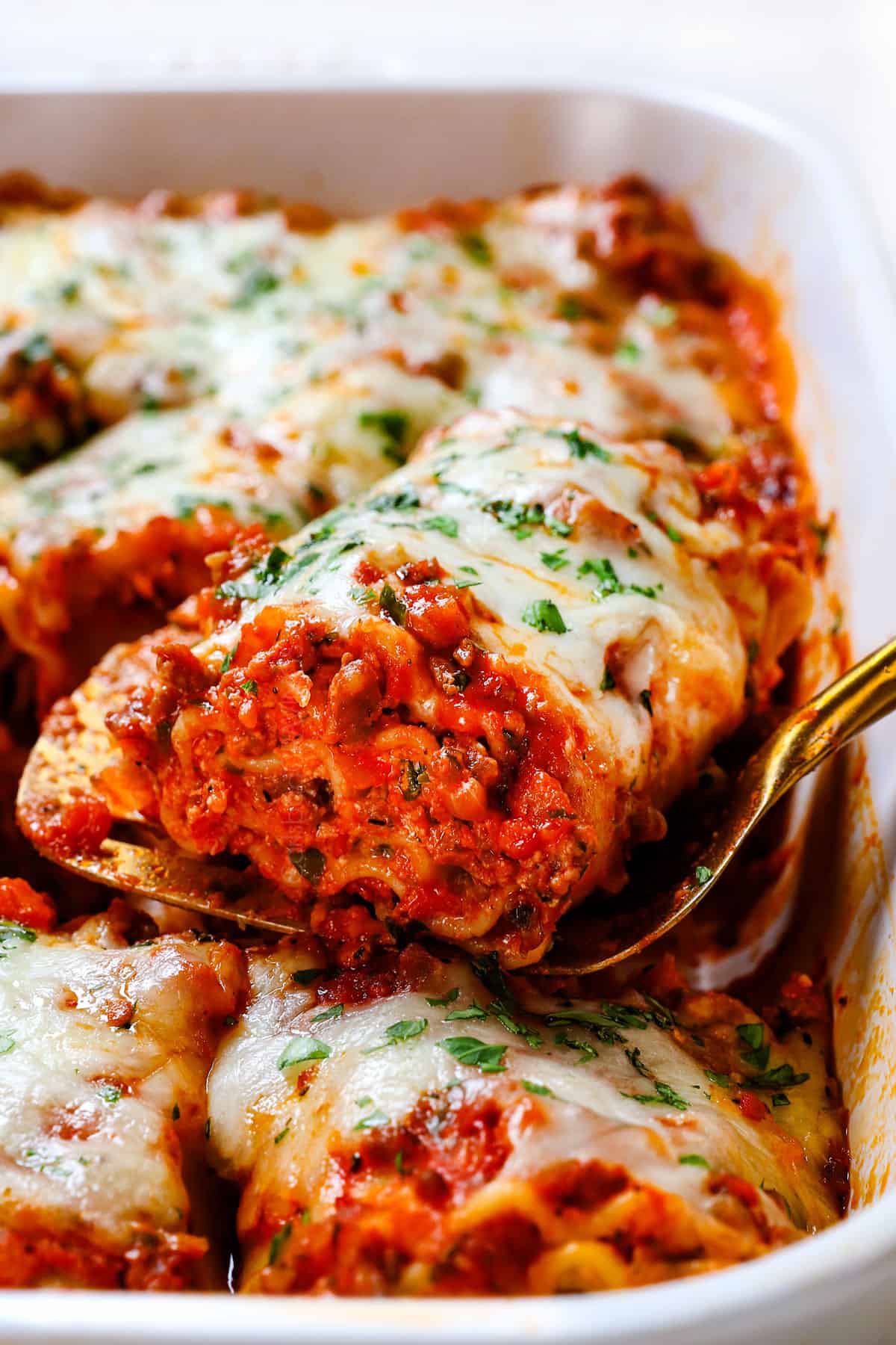 showing how to make lasagna rolls ups recipe by baking until cheese is melted