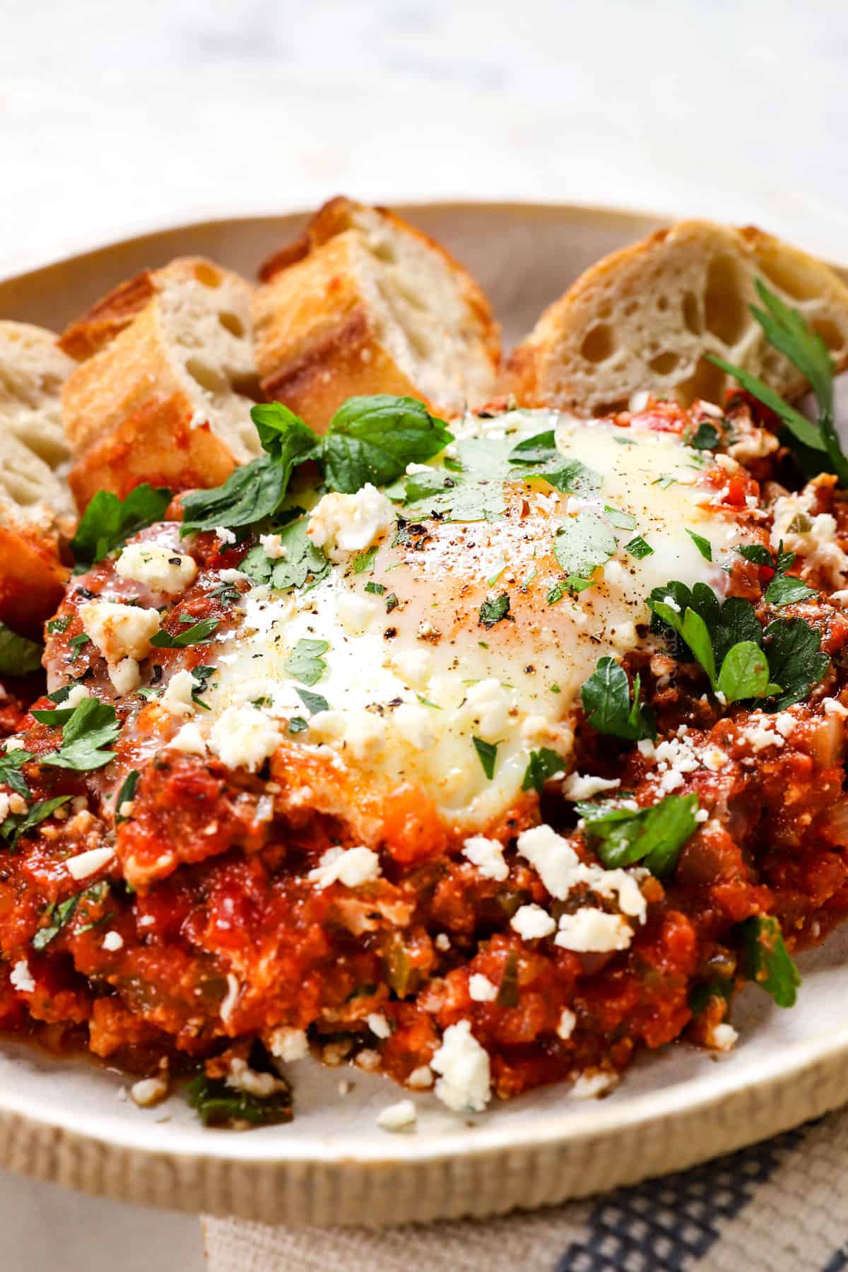 showing how to serve shakshuka on a plate with bread