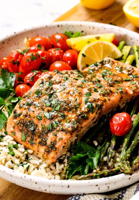 salmon baked in oven being served with rice, tomatoes and asparagus
