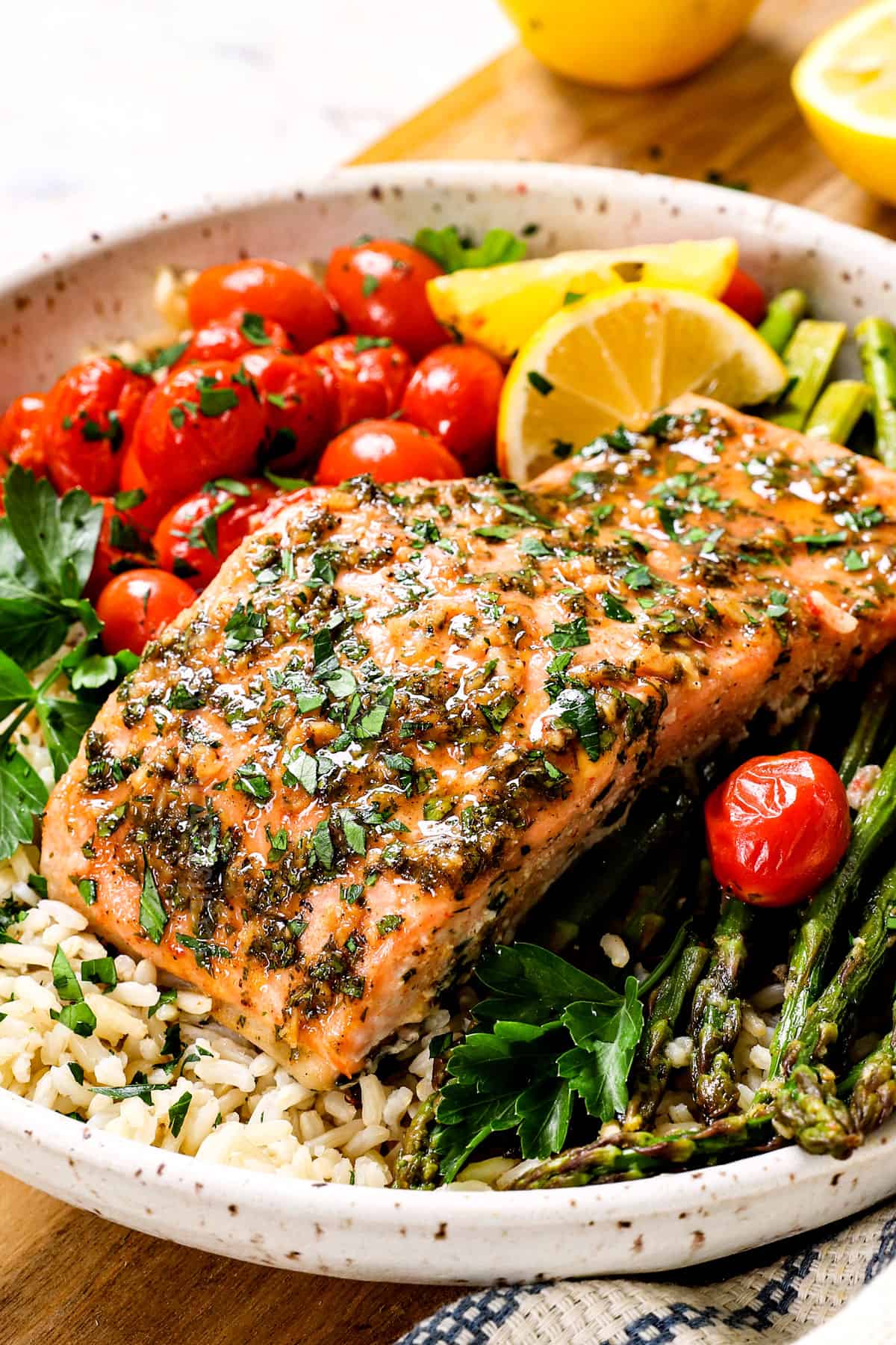 salmon baked in oven being served with rice, tomatoes and asparagus