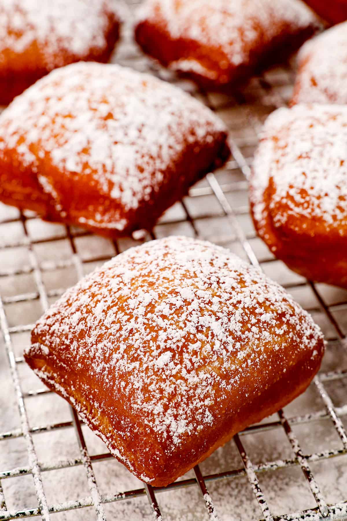 up close of a beignet covered in powdered sugar showing how much to add