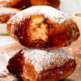 up close of a stack of beignets with a bite taken out showing how soft and fluffy the interior is