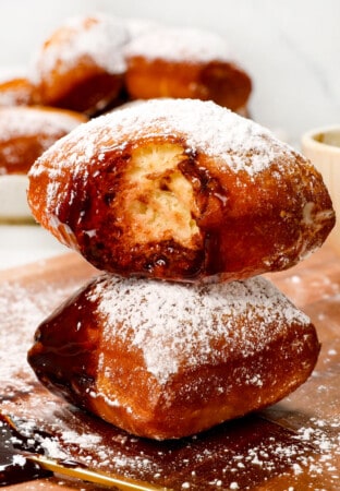up close of a stack of beignets with a bite taken out showing how soft and fluffy the interior is