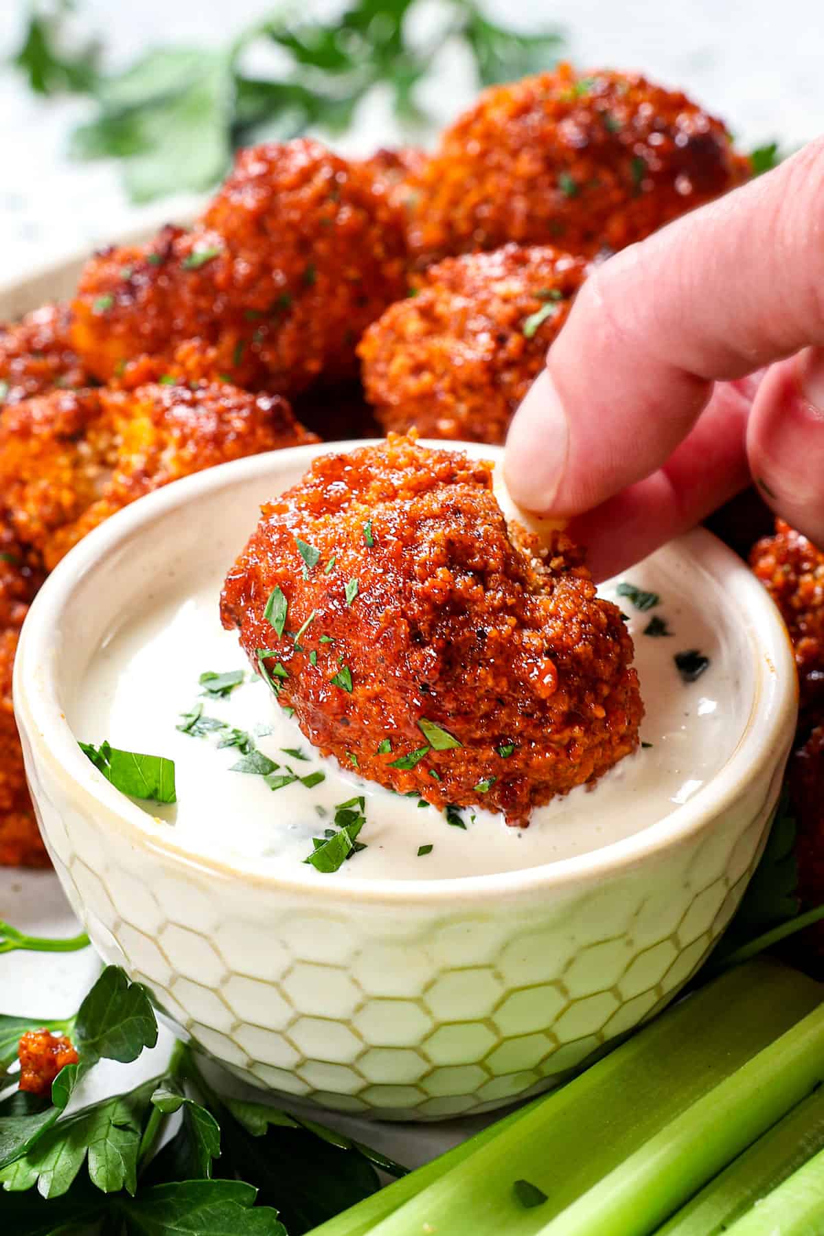 showing how to serve buffalo cauliflower bites by dipping in ranch dressing