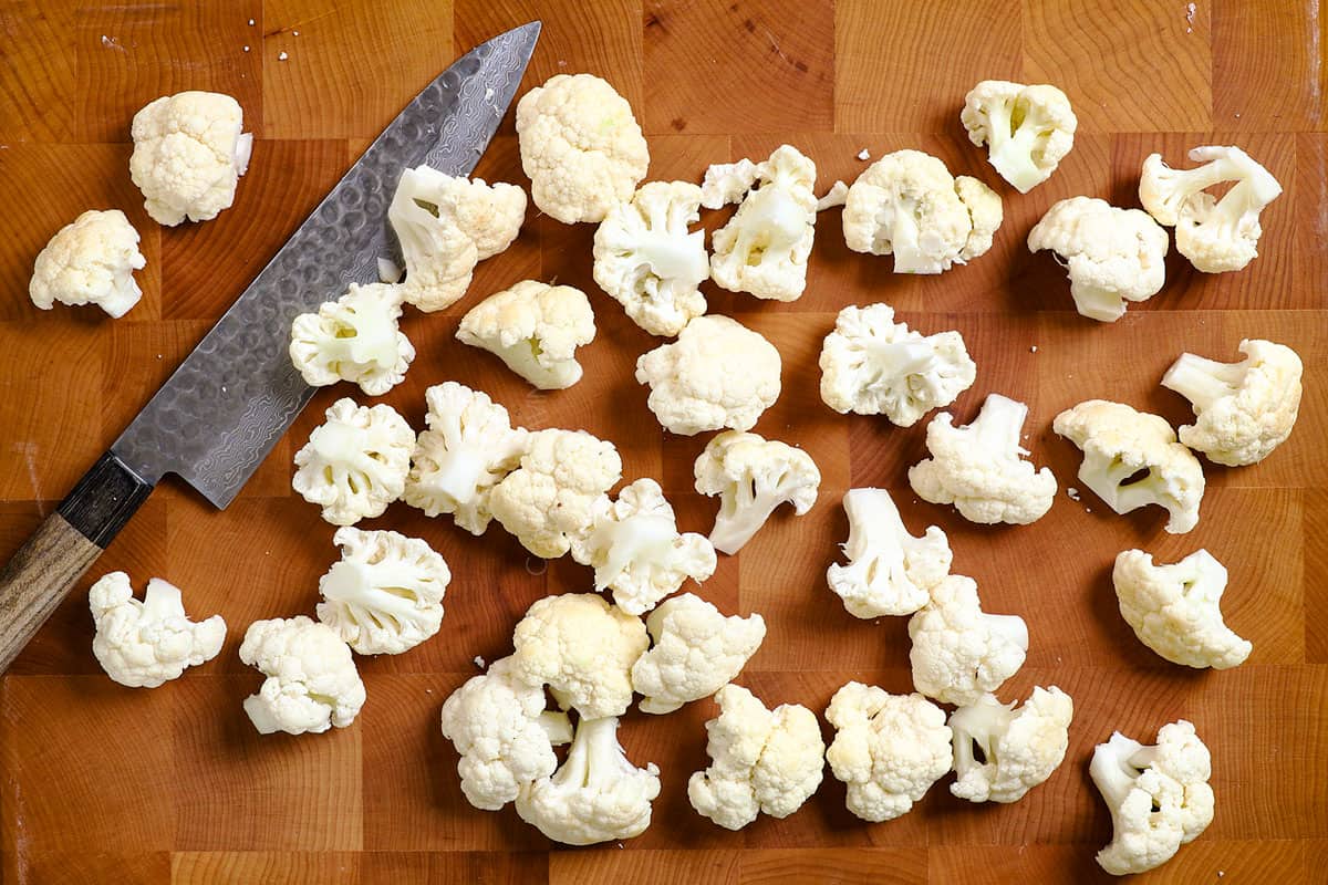 showing how to make buffalo cauliflower by chopping cauliflower into 2-3 inch pieces