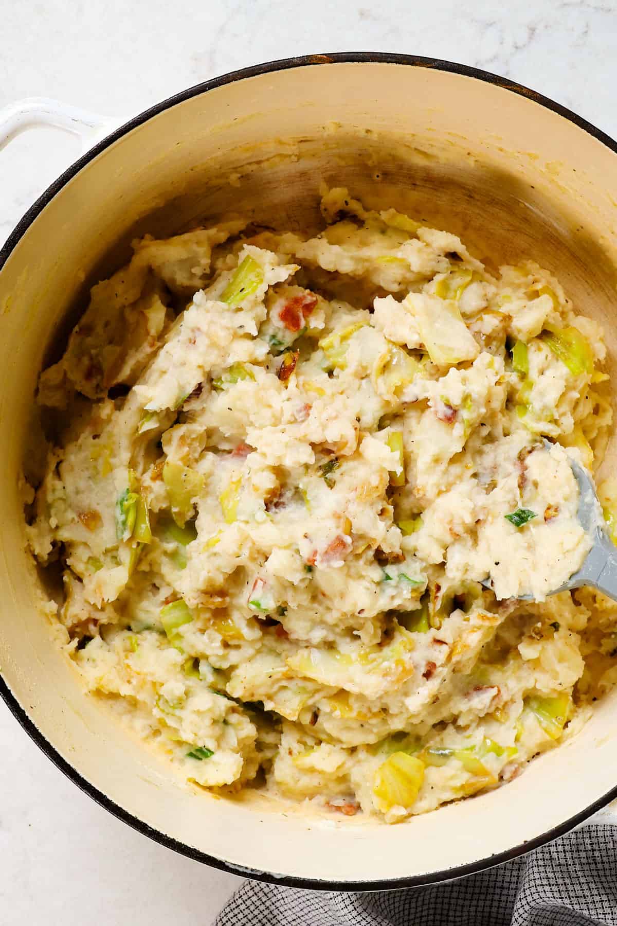 showing how to make colcannon by stirring in cabbage