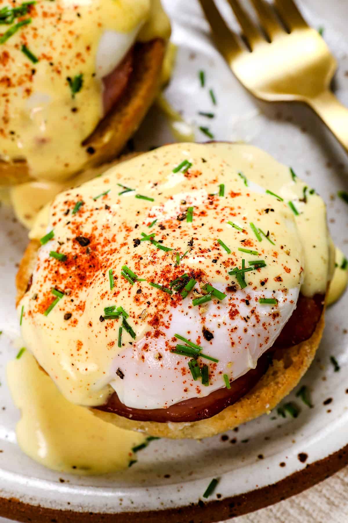serving egg benedict on a plate with a poached egg and Eggs Benedict sauce