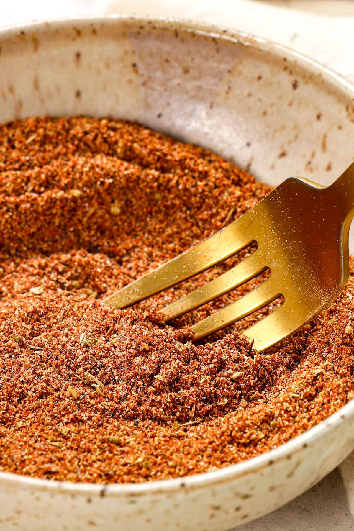 showing how to make taco seasoning by whisking spices together in a bowl