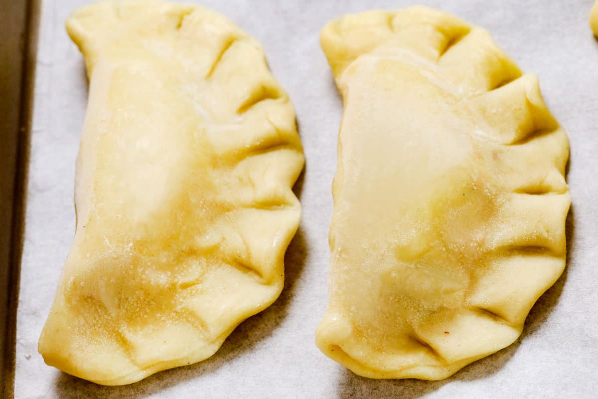 showing how to make pierogi by placing on a parchment lined baking sheet