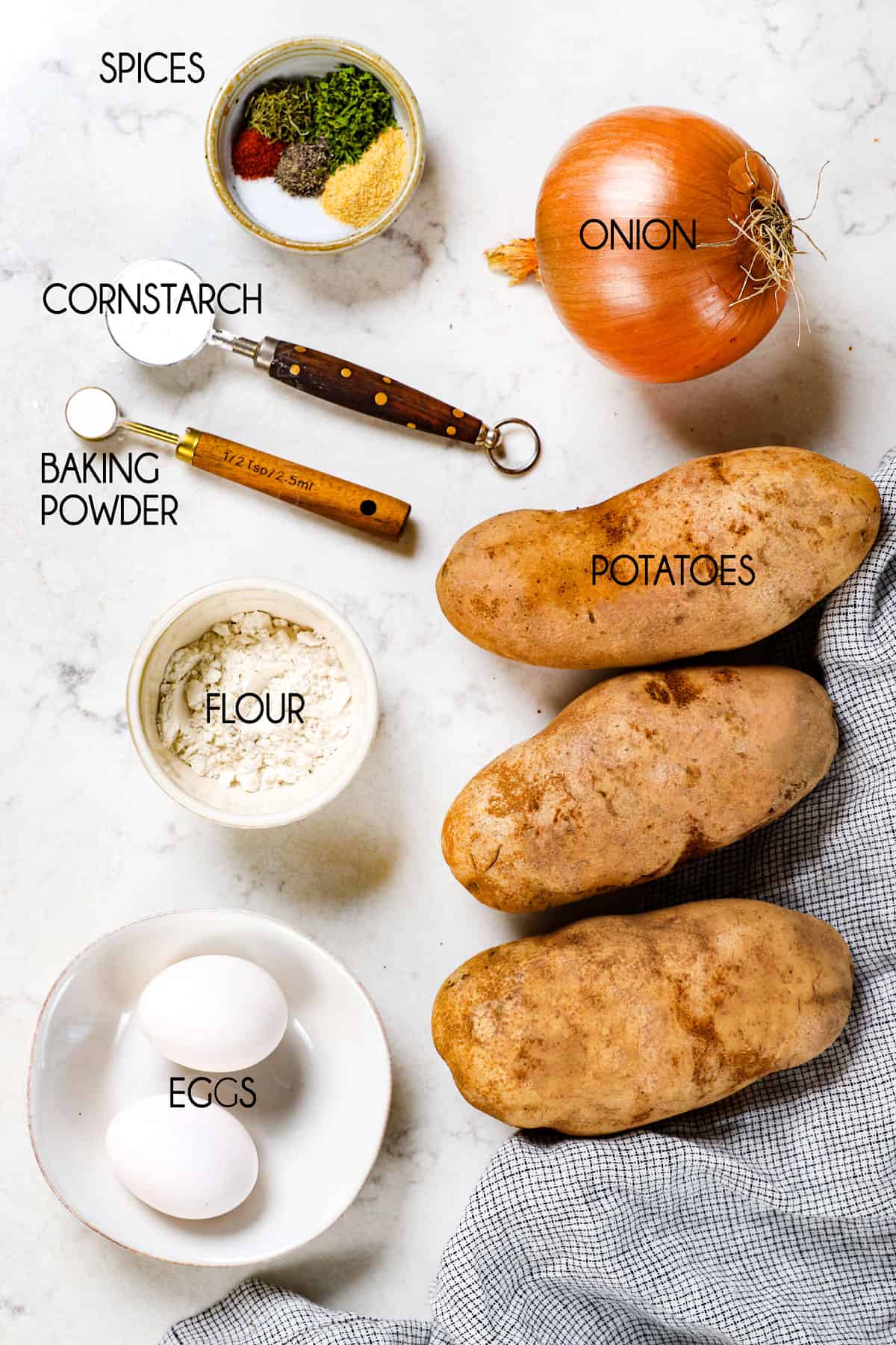 top view showing potato pancake ingredients: potatoes, flour, eggs, onion and spices