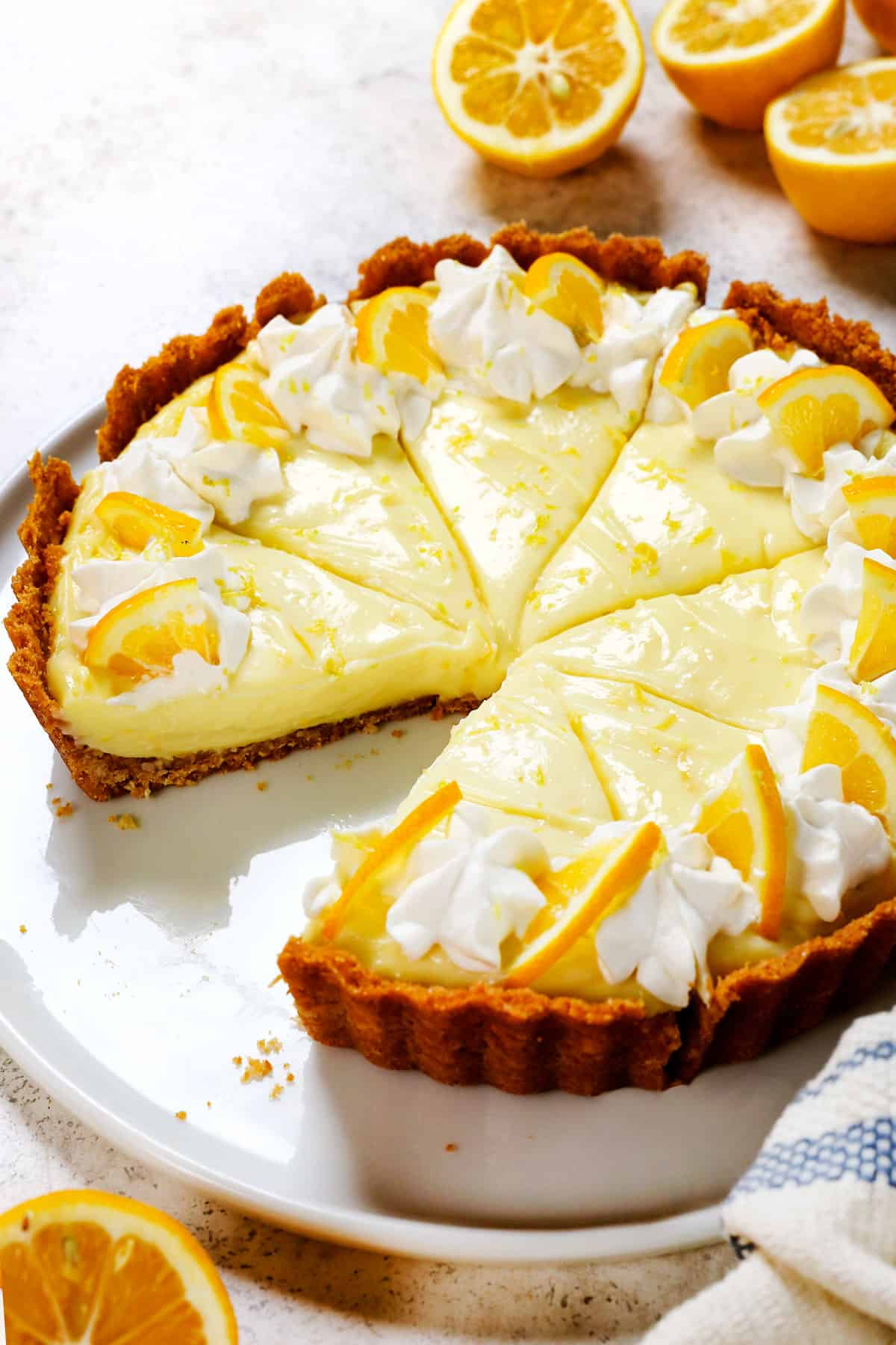 lemon cream pie sliced on a plate decorated with lemon slices