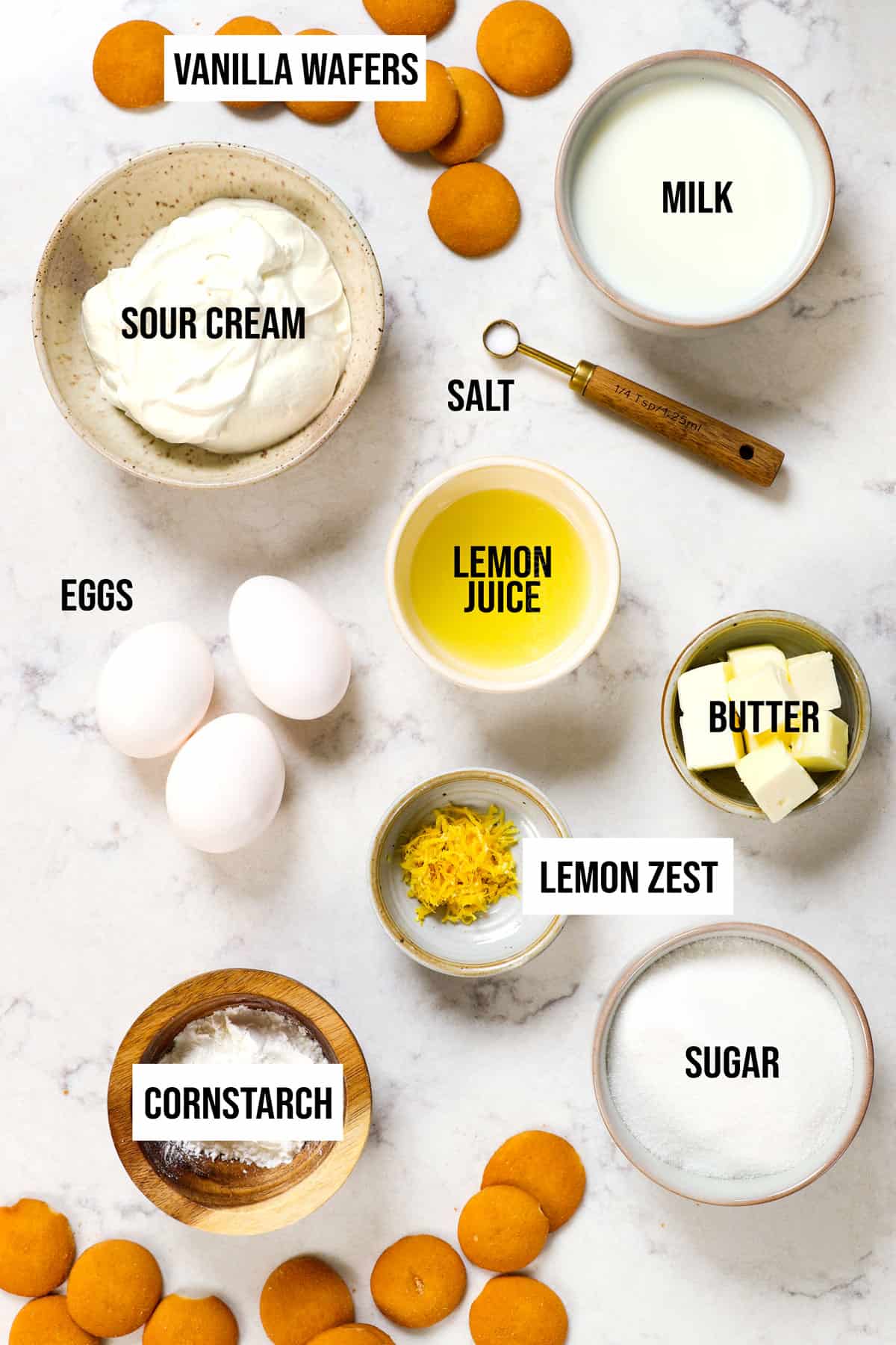 top view of lemon pie ingredients:  lemon juice, lemon zest, cornstarch, sugar, butter, eggs and sour cream