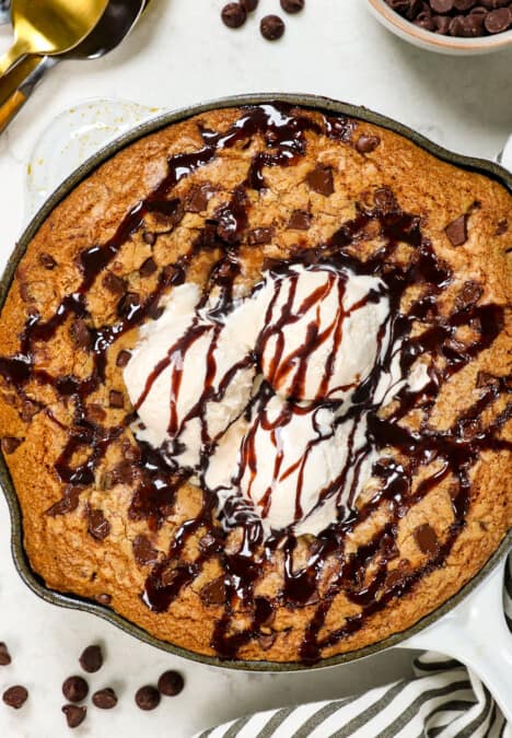 showing how to serve pizookie recipe with chocolate chips drizzled with chocolate sauce