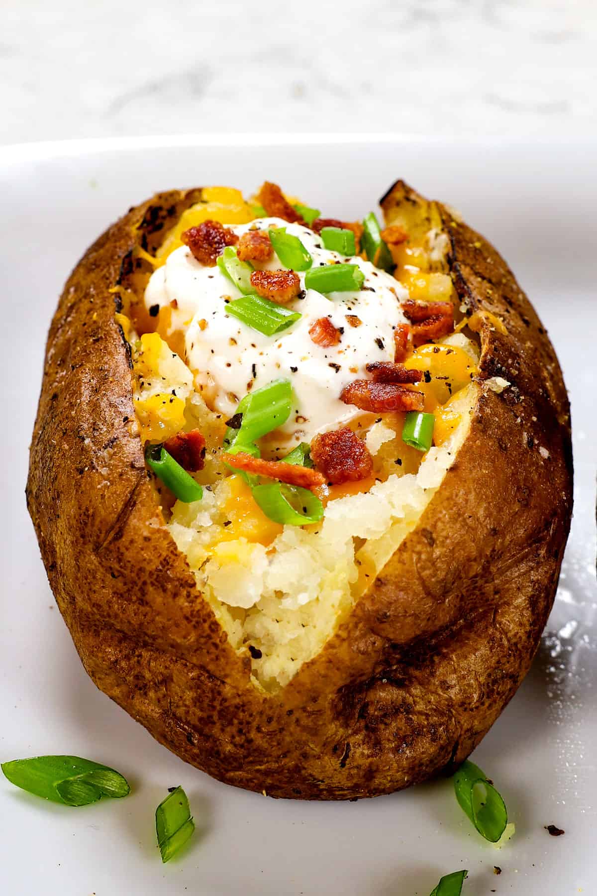 up close of adding toppings to baked potato oven