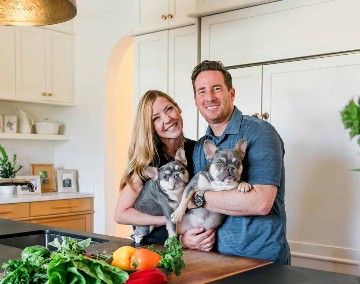 photo of Carlsbad Cravings creator, Jen Sattley with husband Patrick Sattley holding their two French bulldogs