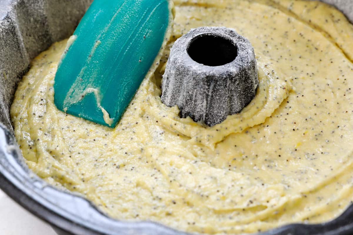 showing how to make lemon poppy seed cake by transferring the batter to a Bundt pan
