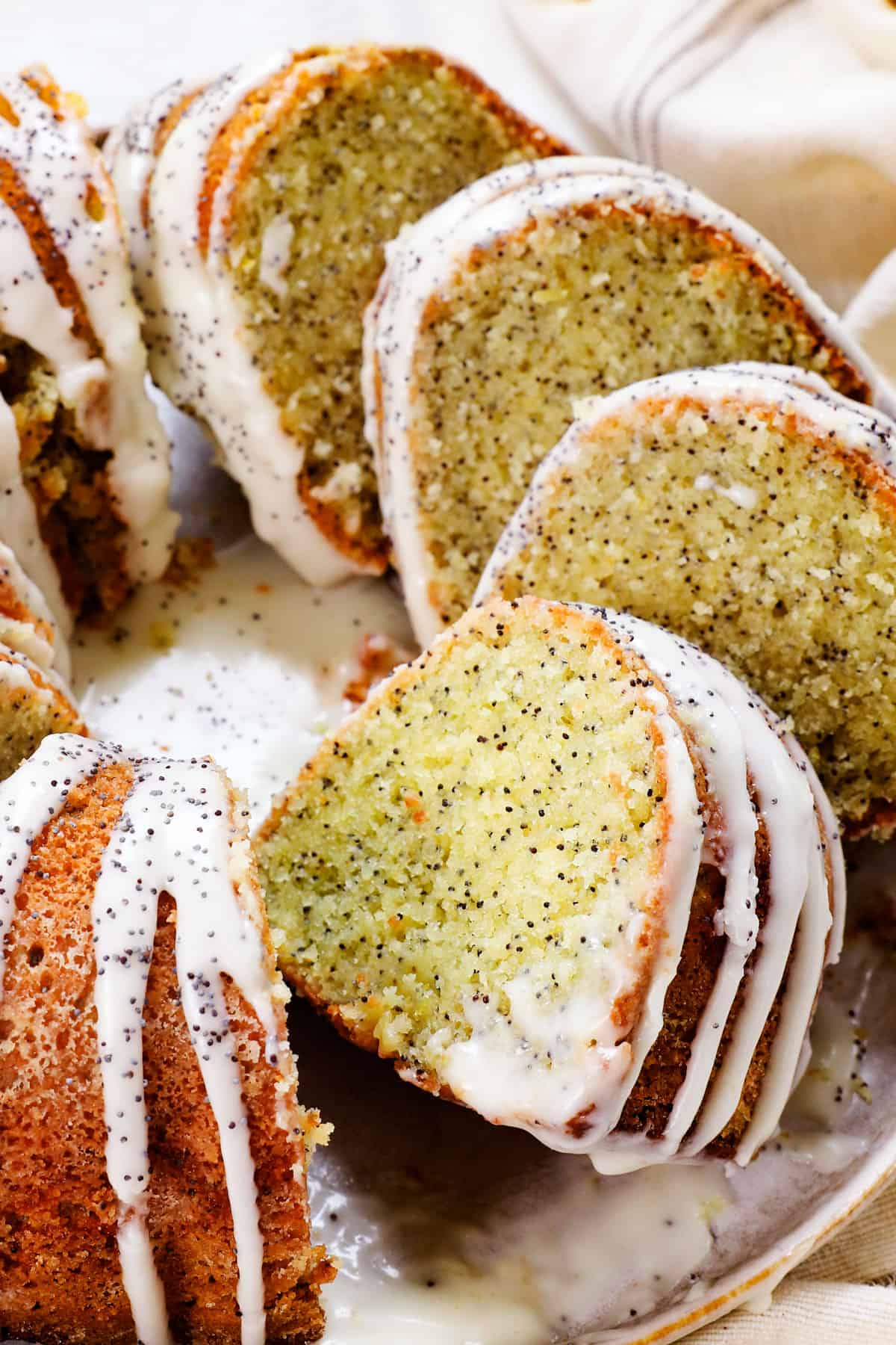 poppy seed cake recipe sliced on a platter garnished with poppy seeds