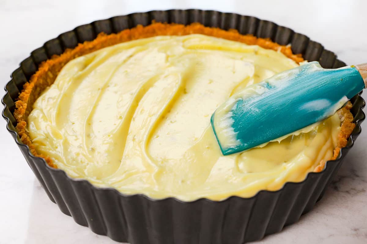 showing how to make key lime pie recipe by adding Key lime filling to the crust and chilling