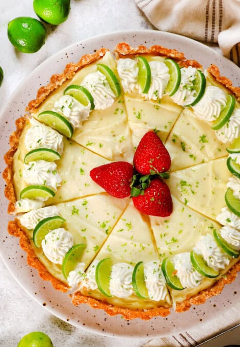 top view of key lime pie garnished with lime slices and whipped cream