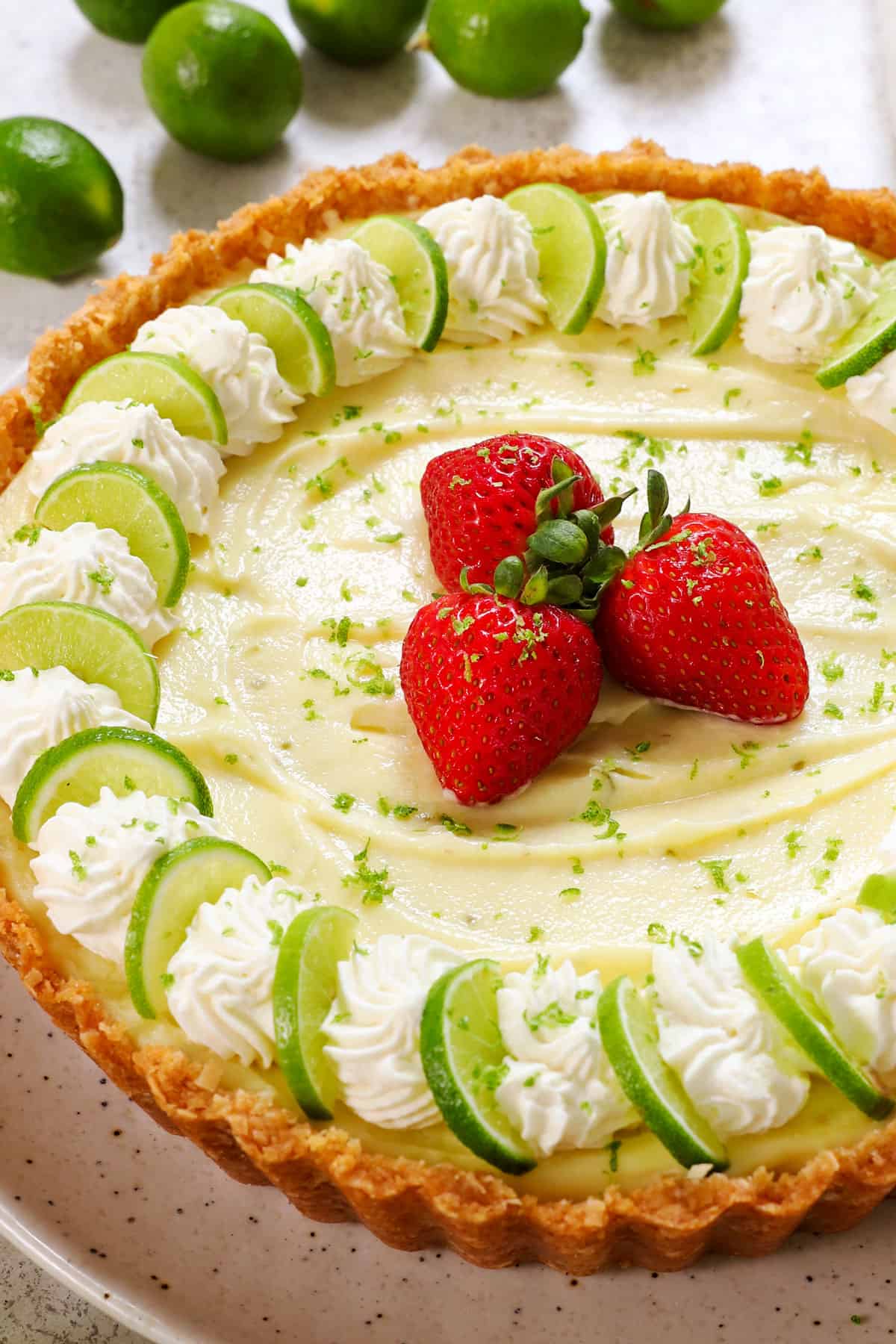 best key lime pie recipe on a serving plate garnished with lime zest